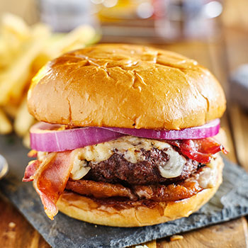 western style bacon burger with onion rings and bbq sauce